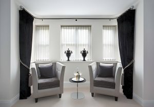 Black curtains with translucent striped blinds inside window frame